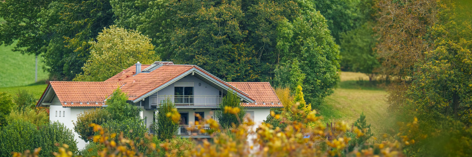 Europäisches Wohnhaus in grüner Umgebung als ruhiger Einstieg zum Immobilienthema