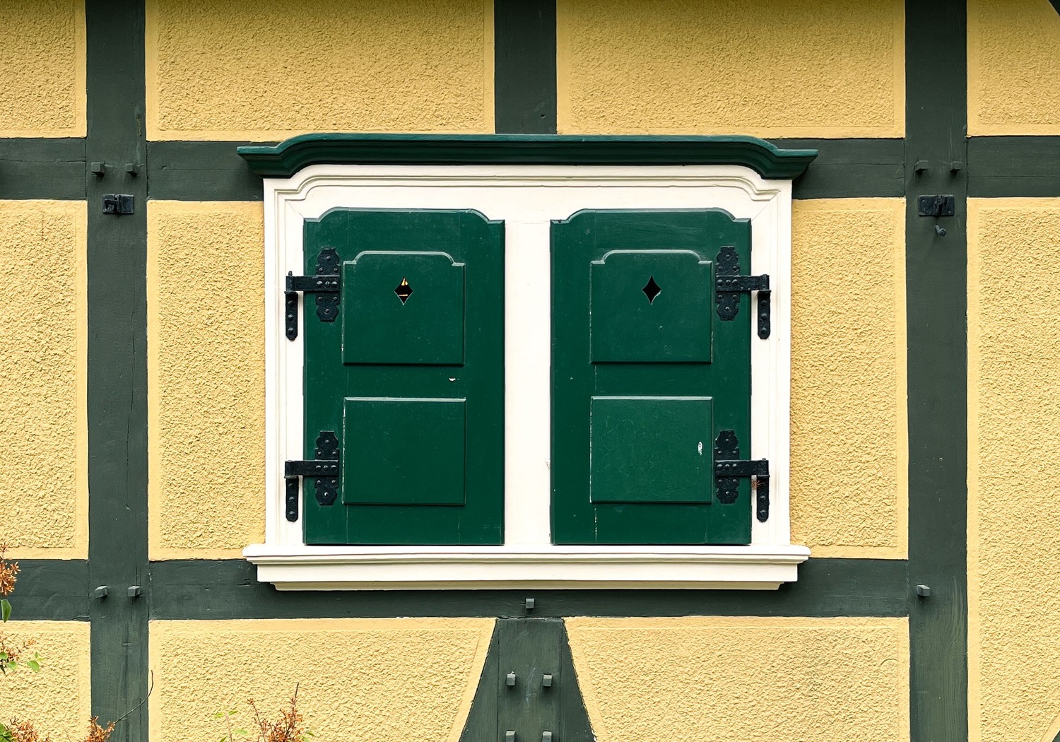 Detail einer traditionellen deutschen Hausfassade mit geschlossenem Fenster und sichtbarer Bausubstanz